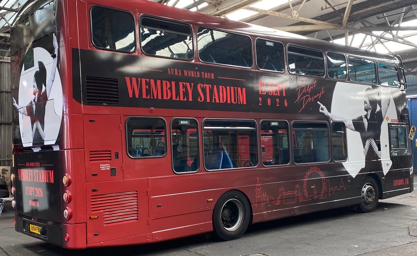 Offside of the wrapped London double-decker, both decks carrying the Aura World Tour creative