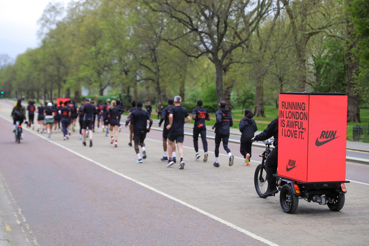 Nike AdBike Pacer riding alongside a group of runners through Hyde Park during the London Marathon