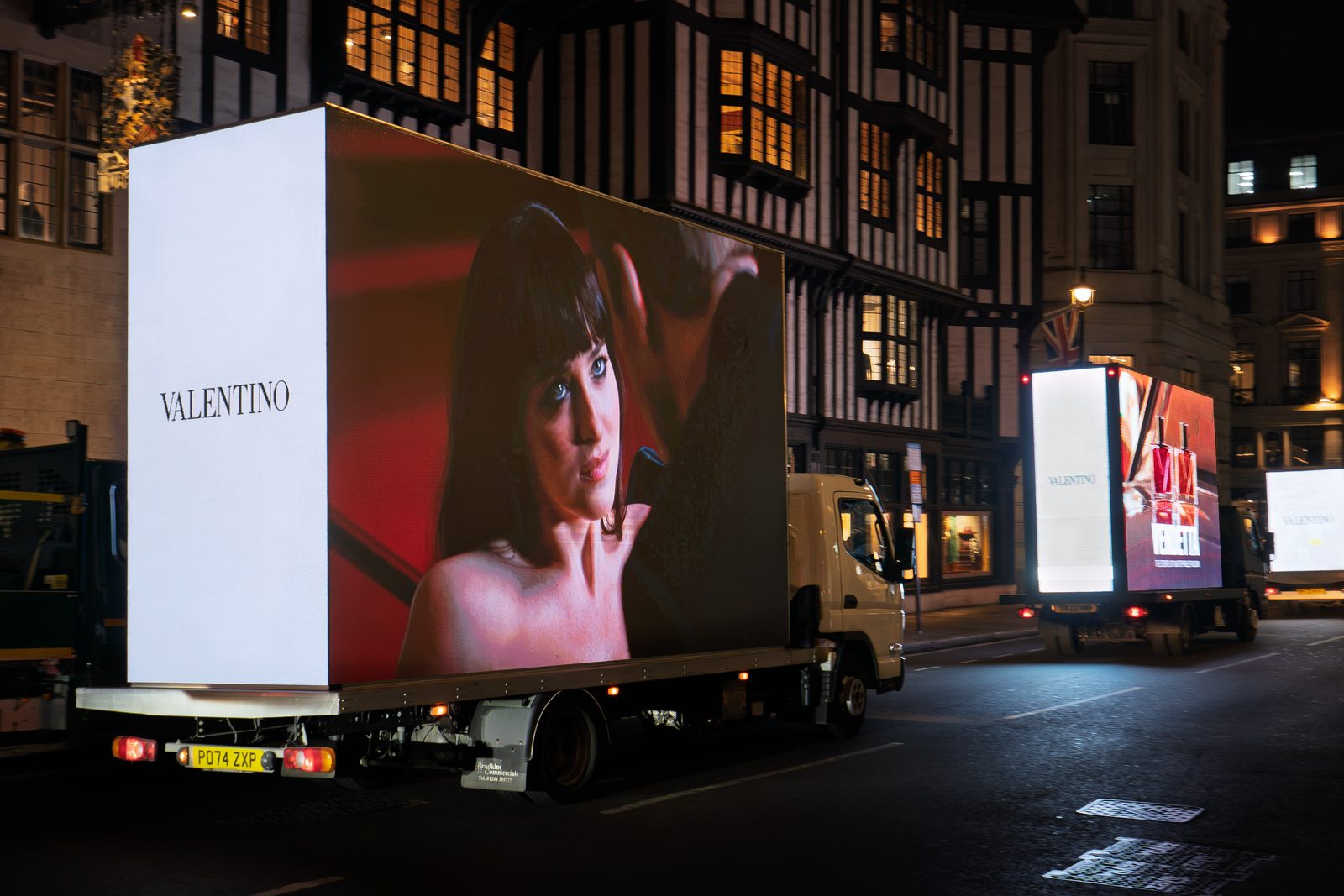 Three Monster AdVans lined up in convoy outside Liberty on Great Marlborough Street at night, carrying the Valentino Vendetta campaign